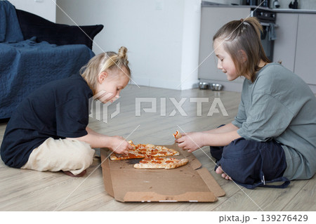 Sibling friends girl and boy eating pizza at home Sibling friends girl and boy eating pizza at home 139276429