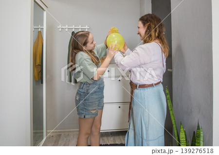 Mom and daughter stand at the entrance of a modern apartment. 139276518