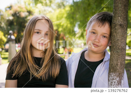 Happy young girl and boy together in park, outdoors portrait. Happy children Happy young girl and boy together in park, outdoors portrait. Happy children 139276762