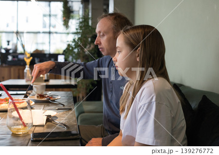 Weekend. Father and daughter eating pizza in restaurant Weekend. Father and daughter eating pizza in restaurant 139276772