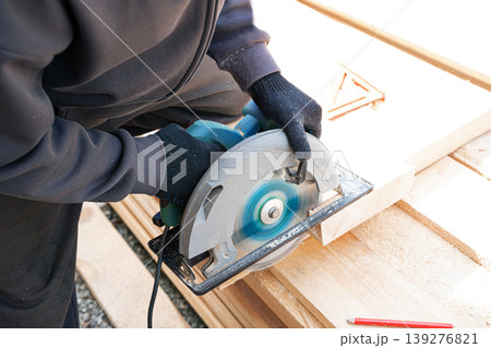 Carpenter man using circular saw to cut timber 139276821