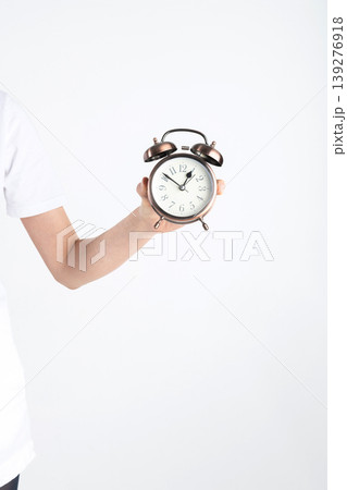Hand holding alarm clock demonstrating time management Hand holding alarm clock demonstrating time management 139276918