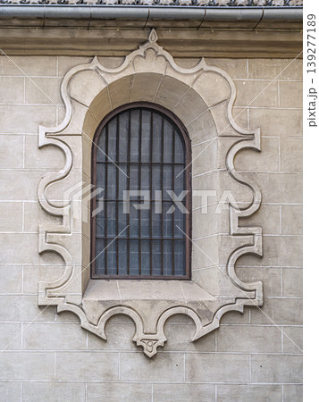 Ornate Arched Stone Window With Decorative Surround and Iron Grille on Historic Facade Ornate Arched Stone Window With Decorative Surround and Iron Grille on Historic Facade 139277189