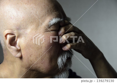 手で顔を覆うヒゲの老人 139279130