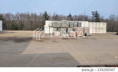 Concrete building blocks stacked on a gravel lot at a construction site, industrial supply chain, infrastructure materials Concrete building blocks stacked on a gravel lot at a construction site, industrial supply chain, infrastructure materials 139280567