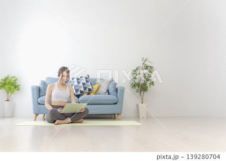 自宅でオンラインヨガを受ける若い女性 自宅でオンラインヨガを受ける若い女性 139280704