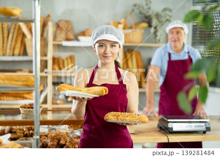 Young smiling woman baker offers to buy fresh delicious bocadillo Young smiling woman baker offers to buy fresh delicious bocadillo 139281484