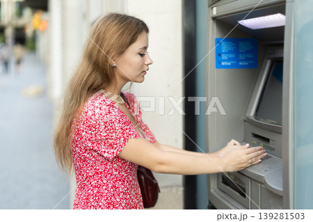 Young woman carefully entering pin code at atm Young woman carefully entering pin code at atm 139281503
