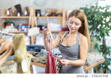 Young woman choosing jumpsuit in clothing store Young woman choosing jumpsuit in clothing store 139281506