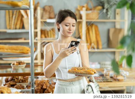 Girl customer holds bocadillo on disposable plate and recognizes it using app 139281519