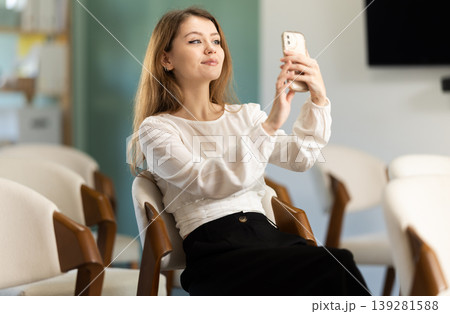 Young woman student scanning QR code with mobile phone 139281588