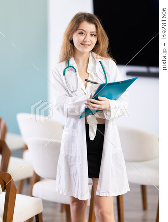 Young female doctor with folder invites in lecture hall 139281606