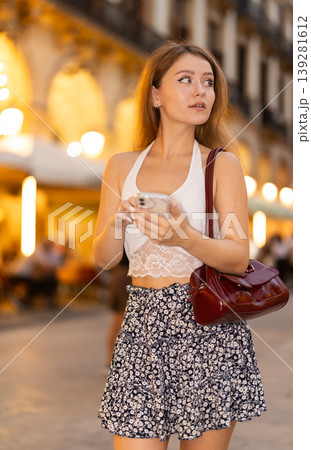 Young woman with phone at Royal Square (Placa Real) in Barcelona Young woman with phone at Royal Square (Placa Real) in Barcelona 139281612