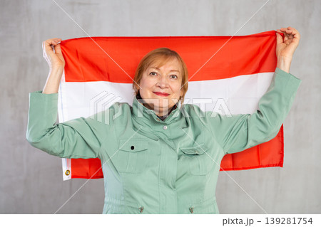 Smiling elderly woman waving flag of Austria in studio Smiling elderly woman waving flag of Austria in studio 139281754