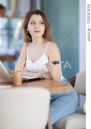 Young woman secretary holding remote control and preparing to turn on presentation Young woman secretary holding remote control and preparing to turn on presentation 139281818
