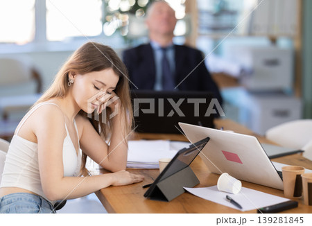 Tired man and woman sleeping in the office with her head on table Tired man and woman sleeping in the office with her head on table 139281845