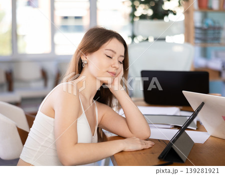 Tired young woman working with tablet in office Tired young woman working with tablet in office 139281921