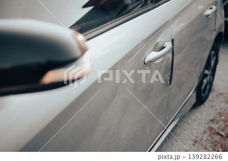 Close-up of damaged white car door with dent and scratch Close-up of damaged white car door with dent and scratch 139282266