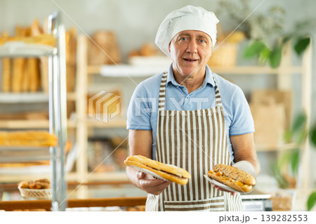 Elderly man seller with bocadillo in bakery Elderly man seller with bocadillo in bakery 139282553
