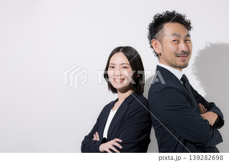 背中合わせで立つ男女ビジネスパーソンの信頼とチームワークイメージ カメラ目線で笑顔 背中合わせで立つ男女ビジネスパーソンの信頼とチームワークイメージ カメラ目線で笑顔 139282698