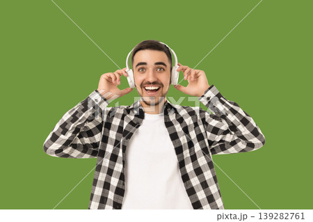 Man smiles widely while listening to music with headphones 139282761