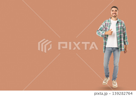 Confident young man in casual attire smiling and giving thumbs up Confident young man in casual attire smiling and giving thumbs up 139282764