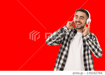 Man smiles while listening to music with headphones on 139282766