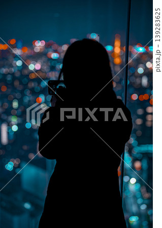 渋谷スカイの展望台から夜景を見つめる女性 139283625