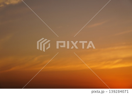 オレンジ色に染まる夕焼け空と流れる雲のグラデーション オレンジ色に染まる夕焼け空と流れる雲のグラデーション 139284071