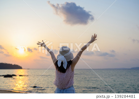 夕焼けの海を見て喜ぶ日本人女性の後ろ姿 夕焼けの海を見て喜ぶ日本人女性の後ろ姿 139284481