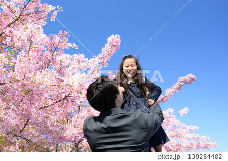 桜の下で子供を抱き上げる日本人の父親 139284482