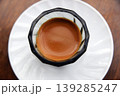 Close up side view of an espresso glass on a white saucer 139285247