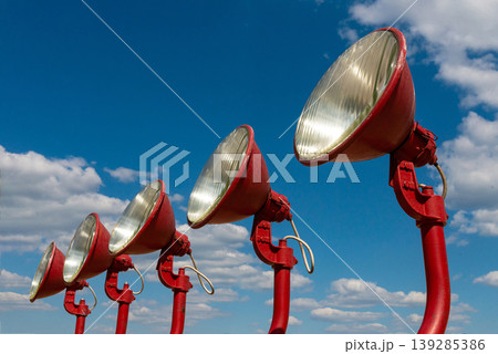 Red loudspeakers aligned outdoors under blue sky Red loudspeakers aligned outdoors under blue sky 139285386