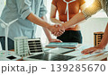 Business handshake over meeting table with laptop, tablet, documents and wind turbine and building models, teamwork and partnership in renewable energy and sustainable development office. 139285670