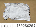 Crumpled paper lying on a brown background. 139286265