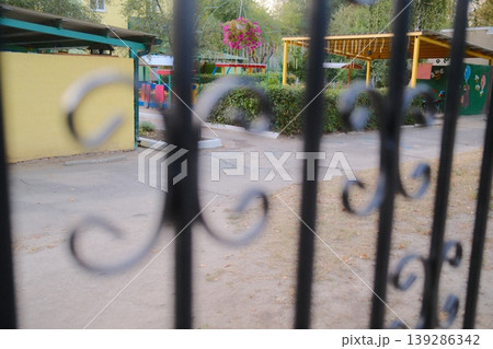 Play area: swings, colorful fence view 139286342