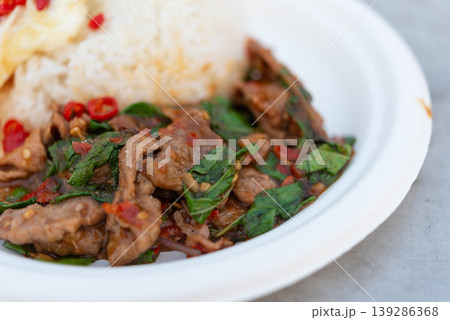 Close up Thai basil beef stir fry with rice and chili savory spicy dish fresh herbs rich sauce popular Thai street food meal Close up Thai basil beef stir fry with rice and chili savory spicy dish fresh herbs rich sauce popular Thai street food meal 139286368