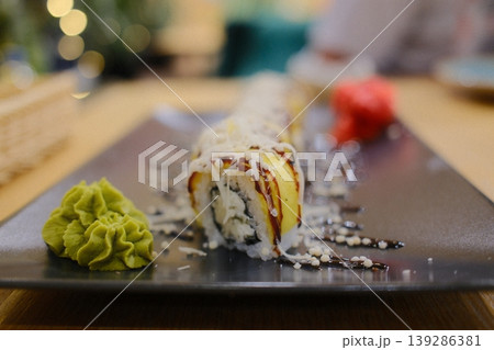 Sushi is garnished with sauce and toppings on a plate, ready to eat 139286381