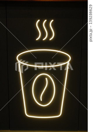 A glowing neon sign features a steaming cup of coffee with a coffee bean on it 139286629