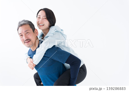 おんぶするスポーツウェアを着たミドル夫婦 おんぶするスポーツウェアを着たミドル夫婦 139286883