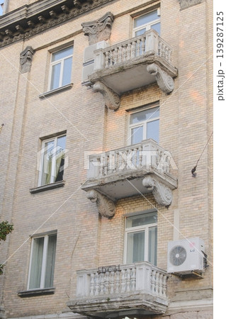 Exterior shot of a multi-story building featuring windows and small concrete balconies 139287125