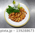 shrimp with sauce and lime wedges on a round white plate 139288673