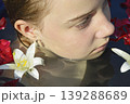 a beautiful girl bathes in a phyto barrel or bath with rose and lily petals 139288689