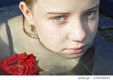a beautiful girl bathes in a phyto barrel or bath with rose and lily petals 139288691