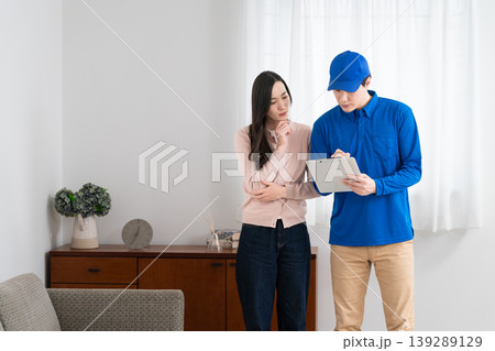 若い女性の引っ越しの見積もりをする若い業者 ライフスタイルイメージ 若い女性の引っ越しの見積もりをする若い業者 ライフスタイルイメージ 139289129