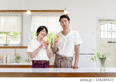 キッチンで乾杯する笑顔の若いカップル キッチンで乾杯する笑顔の若いカップル 139289523