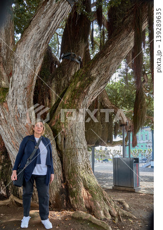 Mature woman standing under a massive tree in Ponta Delgada, Azores, Portugal Mature woman standing under a massive tree in Ponta Delgada, Azores, Portugal 139289635