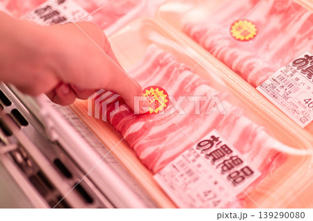 商品に半額シールを貼る店員 139290080