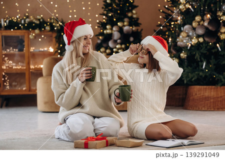Delicious tea in cups. Mother and daughter are celebrating New Year at home in domestic room 139291049