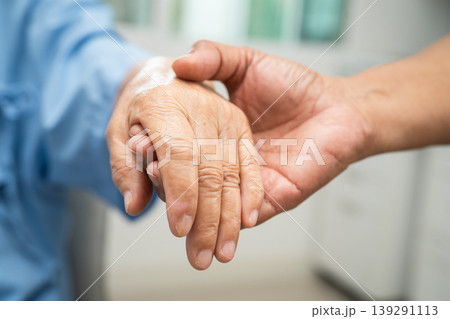 Caregiver holding hands Asian elderly woman patient, help and care in hospital. 139291113